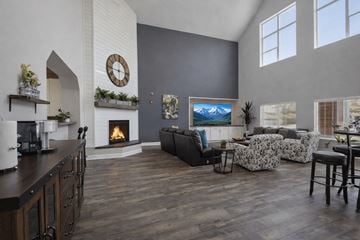Colorado Springs apartment for rent - A living room with a fireplace and a painting of a mountain scene on the wall.
