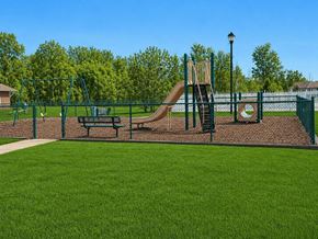 Lansing apartment for rent - A playground with a slide, swings, and a bench.