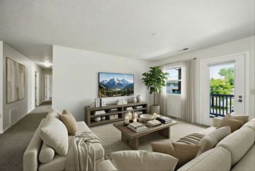 Lansing apartment for rent - A living room with a large couch and a TV displaying a mountain scene.