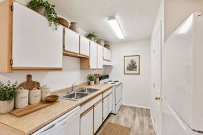 Logan apartment for rent - A kitchen with white cabinets and a wooden cutting board on the counter.