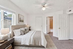 Logan apartment for rent - A bedroom with a large bed and a ceiling fan.