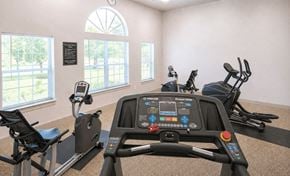 Marietta apartment for rent - A row of stationary bikes in a gym with a clock on the wall.