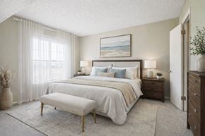 Greeley apartment for rent - A bedroom with a large bed, a bench, and a painting on the wall.