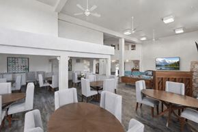 Billings apartment for rent - A modern dining room with white chairs and wooden tables.