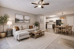Charlotte apartment for rent - A living room with a white sofa, a wooden coffee table, and a ceiling fan.