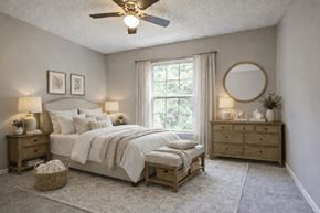 Charlotte apartment for rent - A bedroom with a large bed, a dresser, and a window with curtains.