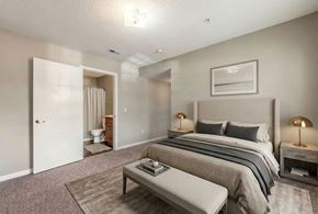 Shelby apartment for rent - A bedroom with a large bed and a bench in front of it.