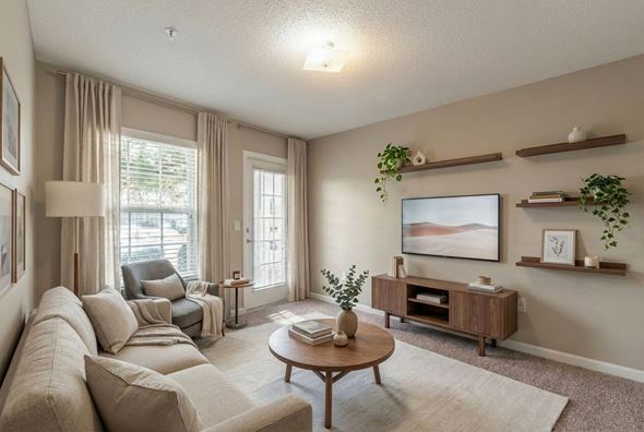 Shelby apartment for rent - A living room with a large couch, a coffee table, and a painting on the wall.