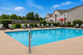 Shelby apartment for rent - A swimming pool surrounded by lounge chairs and a fence.