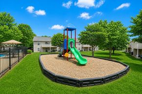Shelby apartment for rent - A playground with a green slide and a red and blue structure.