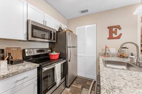 Daytona Beach apartment for rent - A kitchen with a black stove top oven and a black microwave above it at Epic Apartments , Daytona Beach, Florida