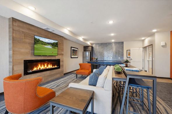 Maple Grove apartment for rent - A modern living room with a fireplace and a television displaying a golf course.