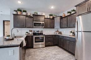 Maple Grove apartment for rent - A kitchen with dark brown cabinets and stainless steel appliances.