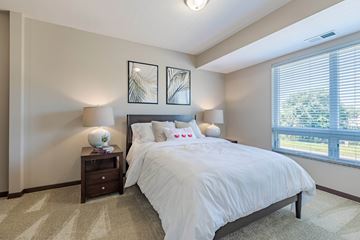 Fridley apartment for rent - A bedroom with a large bed and two lamps.