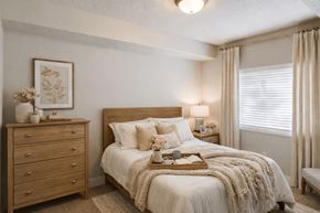 South Jordan apartment for rent - A cozy bedroom with a large bed and a wooden dresser.