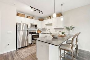 Vadnais Heights apartment for rent - A modern kitchen with a stainless steel refrigerator and wooden flooring at Aster Meadow, Vadnais Heights, MN, 55127