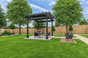 Allen apartment for rent - A gazebo with a table and chairs is surrounded by a grassy area.
