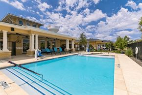 Allen apartment for rent - A large swimming pool with a building in the background.