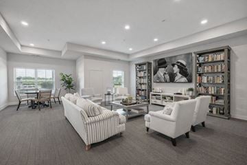Falcon Heights apartment for rent - A living room with a large couch, a chair, and a bookshelf filled with books.