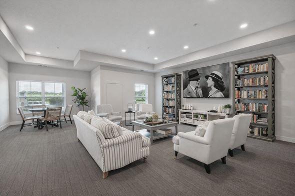 Falcon Heights apartment for rent - A living room with a large couch, a chair, and a bookshelf filled with books.