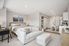 Falcon Heights apartment for rent - A modern bedroom with a large bed and a white couch.
