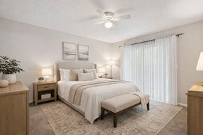College Park townhouse for rent - A bedroom with a large bed and a ceiling fan.