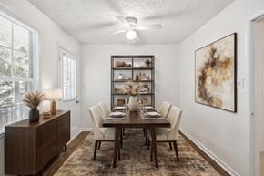 Riverdale apartment for rent - A dining room with a table set for six and a painting on the wall at Emerald Pointe, Riverdale, GA