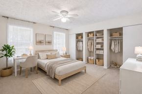 Riverdale apartment for rent - A bedroom with a bed, chair, and a plant at Emerald Pointe, Riverdale, GA