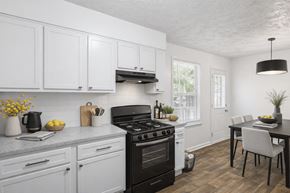 Riverdale apartment for rent - A kitchen with a black stove top oven and white cabinets at Emerald Pointe, Riverdale, GA