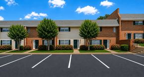 Morrow townhouse for rent - A parking lot in front of a brick building with trees.