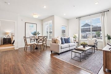 Denver apartment for rent - A living room with a white couch, a coffee table, and a dining table with chairs.