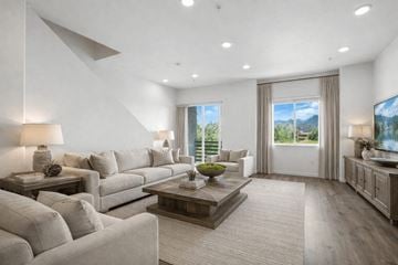 Reno townhouse for rent - A modern living room with a large grey sofa and a wooden coffee table.