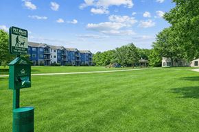Champlin apartment for rent - A sign in a grassy area indicates a pet waste disposal area.