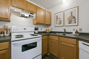 Champlin apartment for rent - A kitchen with wooden cabinets and a white stove top oven.