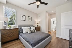 Englewood apartment for rent - Bedroom with gray upholstered bed and ceiling fan at Sequel Homes Apartments, Englewood, Colorado