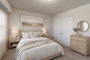 St Cloud apartment for rent - A bedroom with a large bed, a nightstand with a lamp, and a painting on the wall.