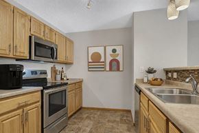 St Cloud apartment for rent - A kitchen with wooden cabinets and a black stove top oven.