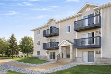 Waite Park apartment for rent - A large two-story apartment building with balconies and a stone pathway leading to the entrance.