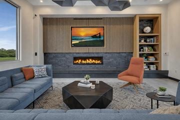 Waite Park apartment for rent - A modern living room with a fireplace and a painting of a sunset on the wall.