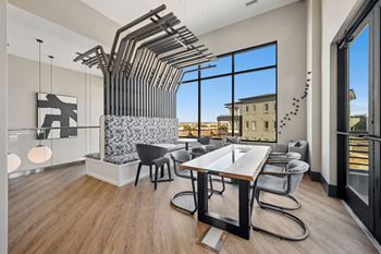 Dining area with modern table and sculptural ceiling installation