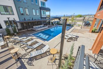 Pool deck with lounge chairs and surrounding buildings