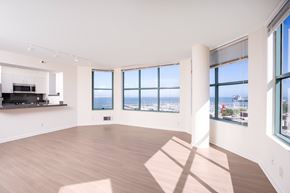 San Francisco apartment for rent - A spacious room with wooden floors and large windows overlooking a cityscape.