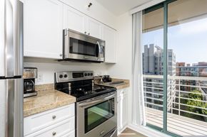San Francisco apartment for rent - A kitchen with white cabinets and stainless steel appliances.