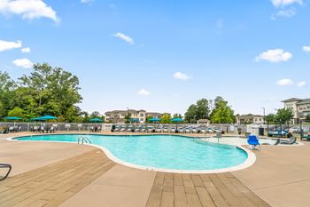 A swimming pool with chairs and umbrellas at the resort on a sunny day