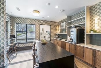 A kitchen with a long wooden table and a large window
