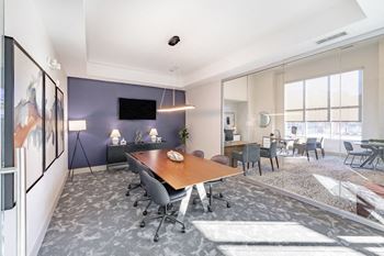 Meeting space with large table and chairs and flat screen tv