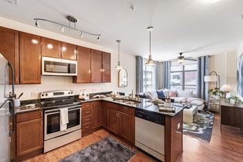 A kitchen with wooden cabinets and a living room with a couch