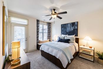 A bedroom with a large bed and a ceiling fan