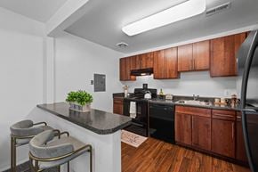 Towson apartment for rent - A kitchen with a black stove top oven and wooden cabinets.