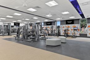 Parkville townhouse for rent - a gym with weights and other exercise equipment on the floor at Doncaster Village Apartments, Parkville, MD